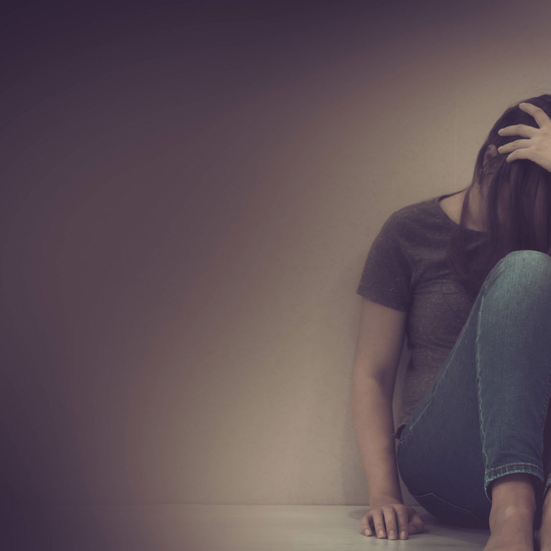 sadness young woman sitting on wood floor looking at empty dark area feeling unhappy and afraid on white wall background with battered abused woman concept. sadness young woman sitting on wood floor looking at empty dark area feeling unhappy and afraid on white wall background with battered abused woman concept.
